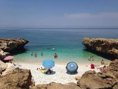 a group of people in the water at a beach at L'isola del sole in Castelluzzo