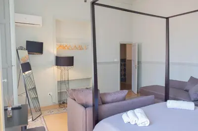 a room with a bed and a couch and a mirror at Al teatro Massimo in Palermo
