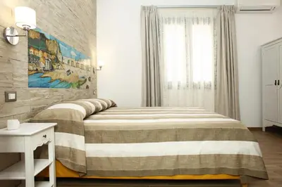 a bedroom with a bed and a painting on the wall at Ninni e Fede in San Vito lo Capo