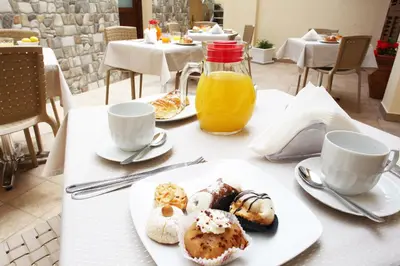 a table with a plate of pastries and orange juice at Ninni e Fede in San Vito lo Capo