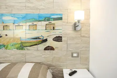 a bedroom with a painting of a river and a boat at Ninni e Fede in San Vito lo Capo