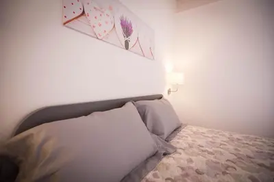 a white bedroom with a bed with a head board at Sciabika Home - Edificio Eolie in Castellammare del Golfo