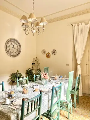 a dining room with a table with chairs and a clock at Casa Jolanda B&B in Palermo