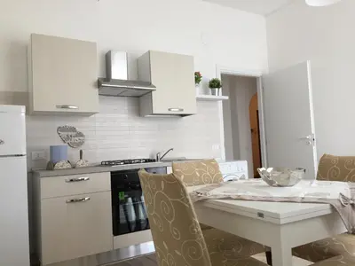 a kitchen with a table and a kitchen with white cabinets at Appartamento al centro vicino il porto in Palermo