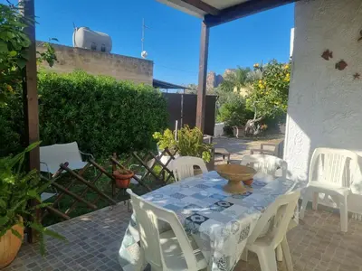 a white table and chairs on a patio at Casa turiddu Makari in Castelluzzo