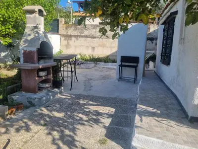 a patio with a table and a stove at Casa turiddu Makari in Castelluzzo