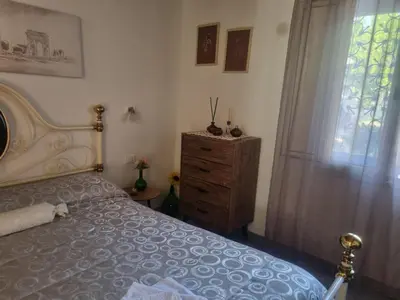 a bedroom with a bed and a dresser and a window at Casa turiddu Makari in Castelluzzo