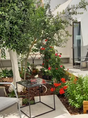a table in front of a garden with flowers at Patio 101 