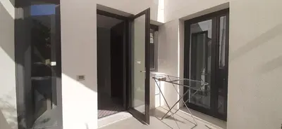a balcony with two glass doors and a metal rack at Patio 101 