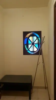 a stained glass window on a wall next to a bench at Le Stelle del Massimo in Palermo