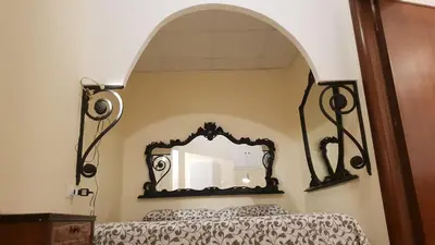a bedroom with a mirror above a bed at Le Stelle del Massimo in Palermo