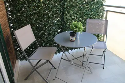 a table and two chairs on a balcony with a plant at B&B D'Amari Affittacamere in Palermo