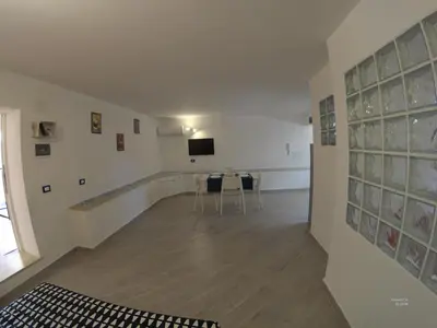 a room with a table and a tv on a wall at la petit maison in Palermo