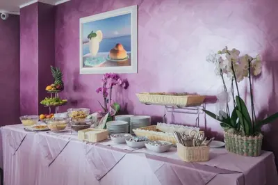 a table with a buffet of food on a purple wall at Le Vele di Balestrate in Balestrate