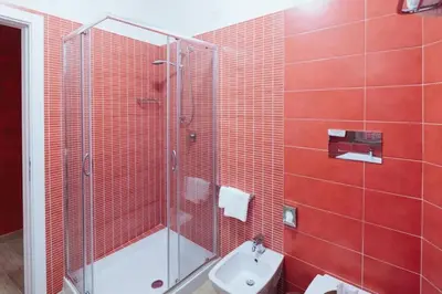 a bathroom with a sink and a shower with red tiles at Le Vele di Balestrate in Balestrate
