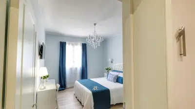 a blue bedroom with a bed and a chandelier at La Via dell'Acqua in Macari