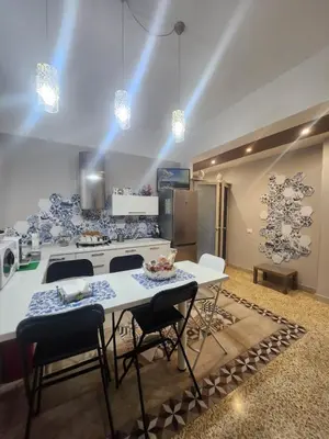 a kitchen with a table with chairs and a refrigerator at 5 cupole in Palermo