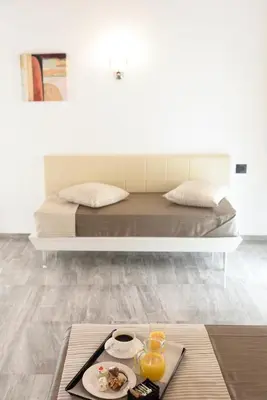 a bed with a tray of food on a table at Best Western Hotel Principe di Lampedusa in Palermo