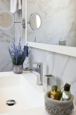 a bathroom sink with a mirror and a vase of flowers at Best Western Hotel Principe di Lampedusa in Palermo