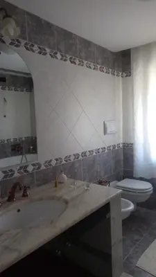 a living room with a white table and a yellow couch at A casa di Elena in Alcamo