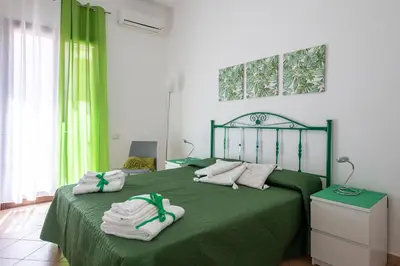 a bedroom with a green bed with towels on it at Casa vacanze Mare Nostrum in Castellammare del Golfo