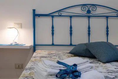 a bedroom with a blue bed with towels on it at Casa vacanze Mare Nostrum in Castellammare del Golfo