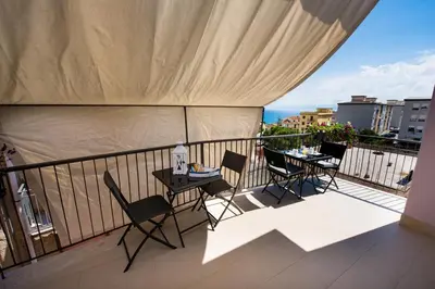 a balcony with tables and chairs on a balcony at Casa Mariú in Castellammare del Golfo