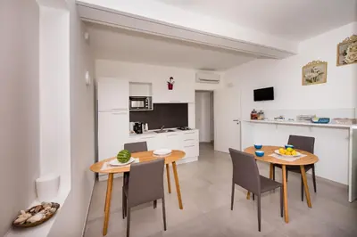 a kitchen and dining room with a table and chairs at Casa Mariú in Castellammare del Golfo