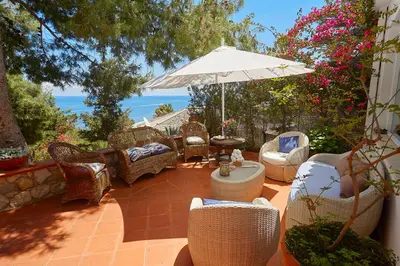 an outdoor patio with chairs and an umbrella at Villa Gabry in Bagheria