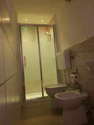 a bathroom with a toilet and a glass shower at La Casetta in Palermo