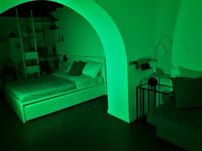a green room with a bed and a lamp at Palermo Home White Home in Palermo