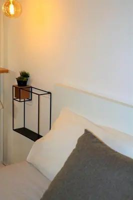a bedroom with a white bed and a plant on a shelf at Palermo Home White Home in Palermo