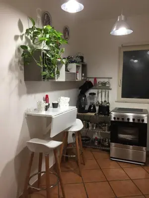 a kitchen with a table and two stools and a stove at Virginia House in Palermo