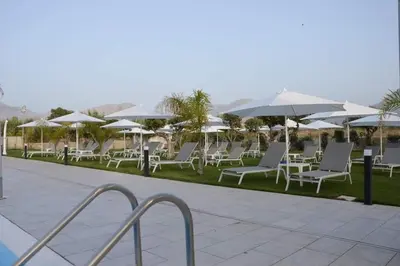 a row of white chairs and umbrellas at Piano Monaco in Carini