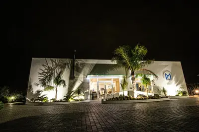 a white building with palm trees in front of it at Piano Monaco in Carini