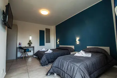 a hotel room with two beds and a television at Piano Monaco in Carini
