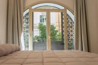a bedroom with a bed and an open window at Central Mezzanine in Palermo