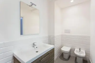 a white bathroom with a sink and a toilet at Central Mezzanine in Palermo