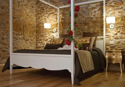 a bedroom with a bed in a stone wall at Borgo degli Angeli Wellness & Resort by Le Dhome Sicily in Balestrate