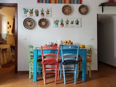 a table with colorful chairs and plates on the wall at Casa Vacanze Villa D'Orleans in Palermo