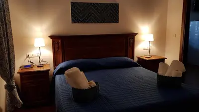 a bedroom with a bed with two chairs and two lamps at Casa Vacanze Villa D'Orleans in Palermo