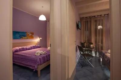 a bedroom with a bed and a table in a room at Affittacamere da Noemi in Castellammare del Golfo