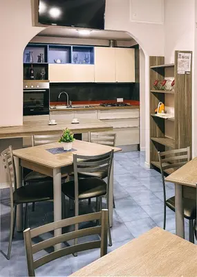 a kitchen with a wooden table and chairs at Affittacamere da Noemi in Castellammare del Golfo
