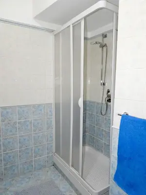 a shower in a bathroom with blue tiles at B&B Maria Piddu in Palermo