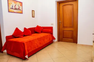 a red bed with red pillows in a room at B&B Maria Piddu in Palermo