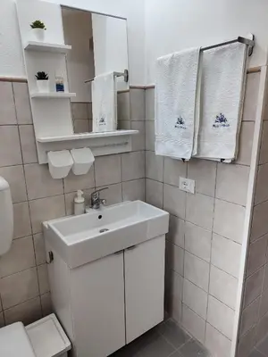 a bathroom with a sink and a toilet and towels at Elegant Villa with Private Pool in Alcamo Marina – Sea View in Alcamo Marina