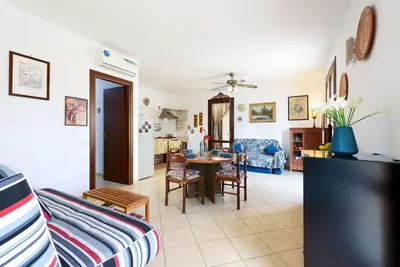 a living room with a table and a dining room at Casa Marisa in San Vito lo Capo