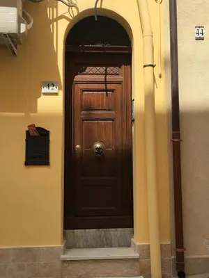 a wooden door in a building with an archway at Casa Vacanze Mannina in Castellammare del Golfo