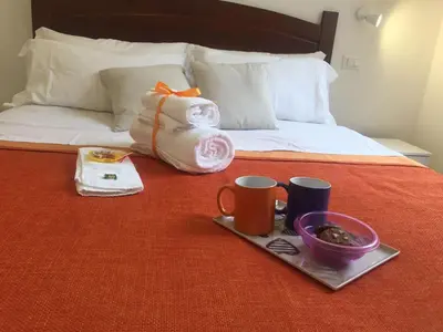 a tray of food and two cups on a bed at YooRoom in Palermo