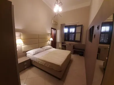 a small bedroom with a bed and a window at Ghibli Hotel in San Vito lo Capo